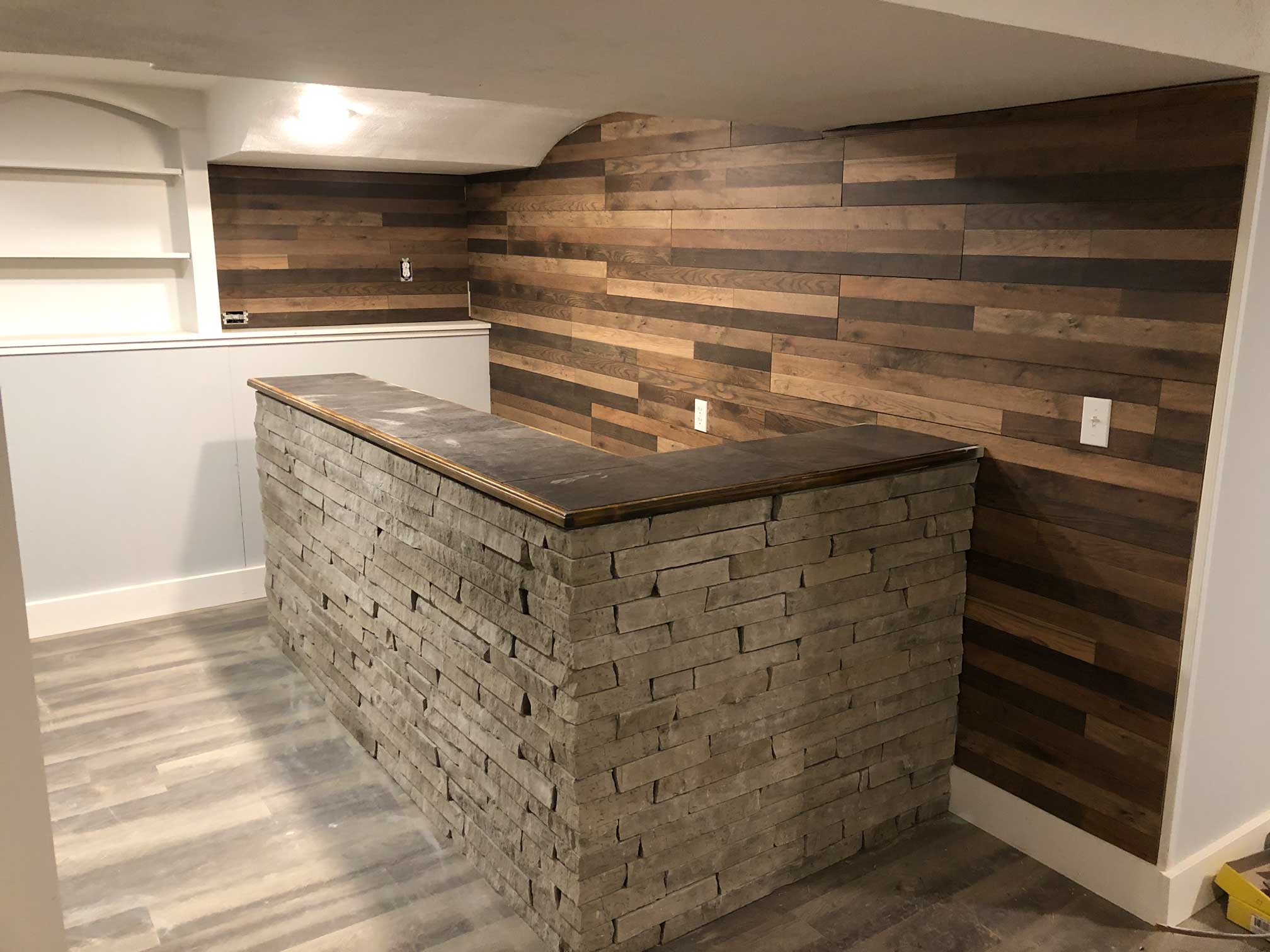 Basement bar with stonework and custom wall paneling